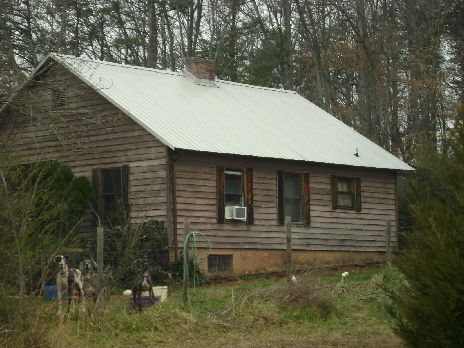White metal roof on an old wood sided farmhouse, from a Metal Roof Installation job in Woodside